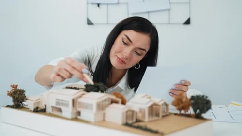 Closeup of beautiful architect measure the architectural model. Immaculate.