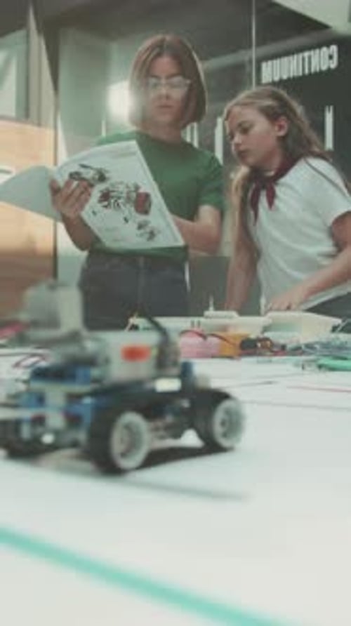 Des Filles Analysent Les Instructions Des Appareils Électroniques De Jeunes Femmes Collaborent À La Construction Moderne