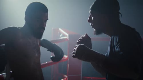 Boxer and Coach Discuss Strategy in Ring