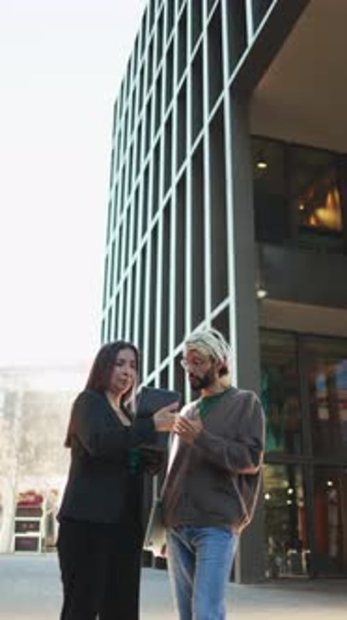 Businesswoman and Man Discussing Tablet Outside Office