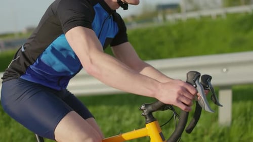 Selbstbewusster Mann mit Helm fährt Carbon-Fahrrad im Freien