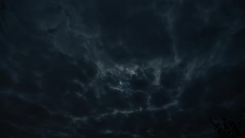 Dark Clouds Pass Silently Across Night Sky