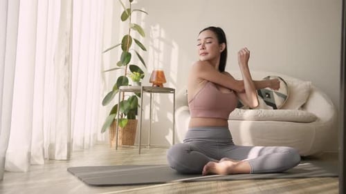 Woman Stretching Arms on Yoga Mat at Home