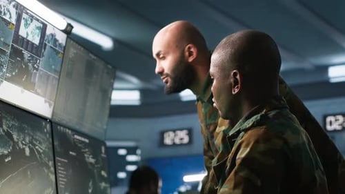 Men Analyzing Maps in High Tech Surveillance Room