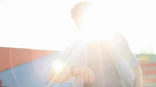 Man Using Smartwatch Outside in Bright Sunlight