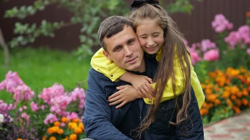 Heartwarming Moment of a Daughter Embracing Her Father in a Blooming Garden