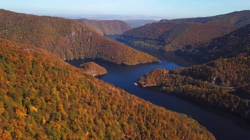Panoramic aerial shot of lake Tarnita, Romania, surrounded by colorful autumn trees