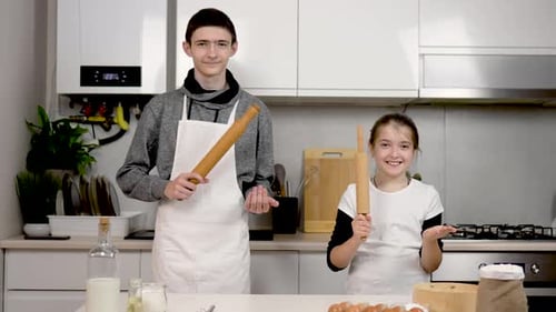 Teen and Child Baking Together in Bright Kitchen