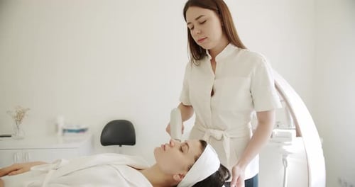 Woman Receives Modern Beauty Treatment in White Room