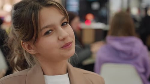 White Teen Influencer Sipping Drink in Crowded Food Court Purple Hoodie Background Orange Cup Smirk