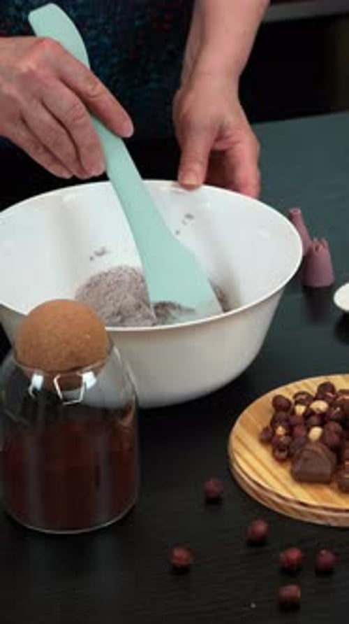 Frau rührt Teig in einer Schüssel mit Teigspatel um und bereitet Kuchen zu. Vertikales Video
