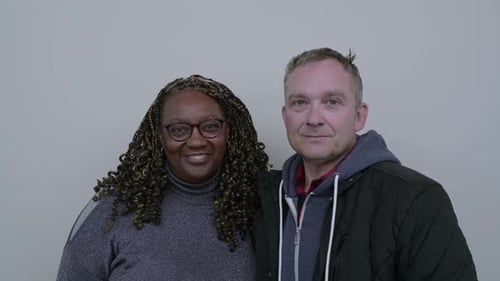 Portrait of beautiful mixed race couple, against a plain wall.