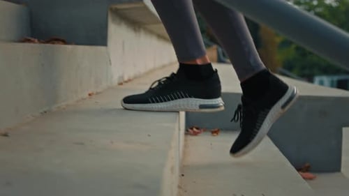 Active Woman in Sports Sneakers Climbing Stairs on Stadium Area Close Up Female Athletic Legs