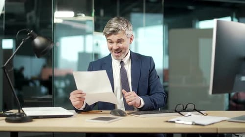 satisfied mature businessman in suit reads a document. happy Handsome young man looking and checking