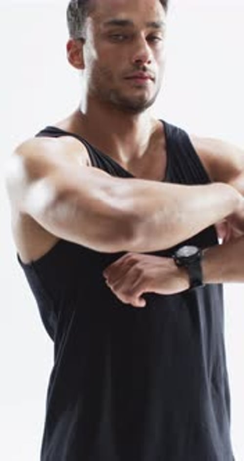Muscular Man Crosses Arms in Studio