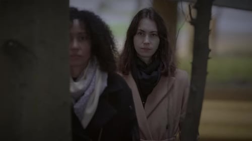 Lifestyle Portrait of Two Young Women Watching Tower Building Together