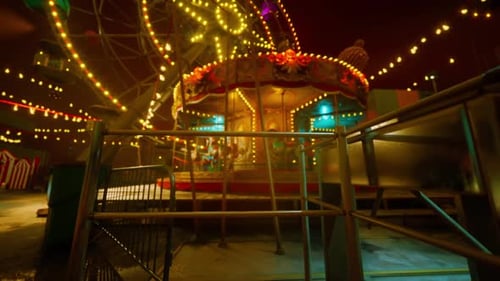 Empty Amusement Park at Night with Bright Lights and a Deserted Carousel