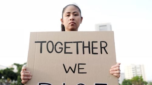 Woman rights. Asian activist holding banner at demonstration in road city. Power, freedom, equality
