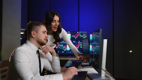 Financial Analysts Collaborating on Stock Market Data at Night