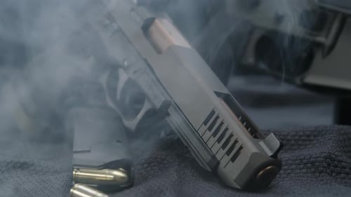 Atmospheric View of Guns on Table with Smoke
