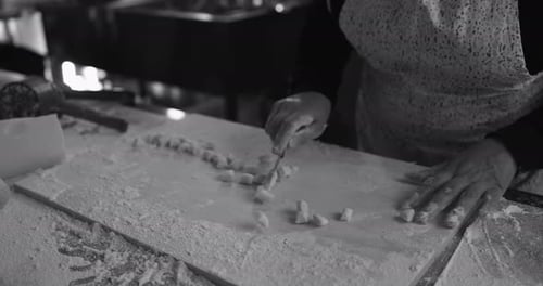 Woman Kneads and Preparing Dough for Fresh Made Gnocchi Inside Pasta Factory Background