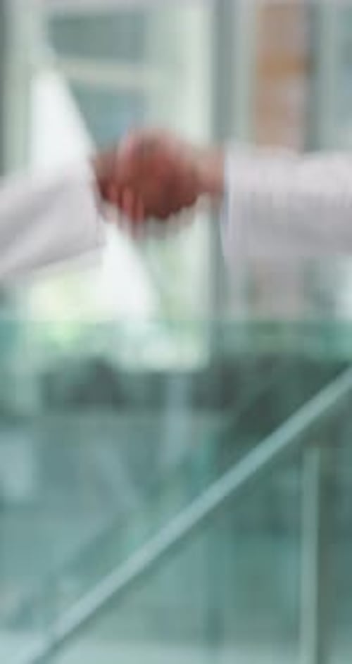 Doctors, shaking hands and agreement in hospital hallway with greeting, deal or welcome for hiring