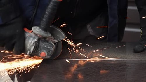 Worker Cuts Metal with Power Tool Sparks Flying