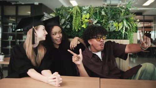 Young graduate students taking a selfie together at college.