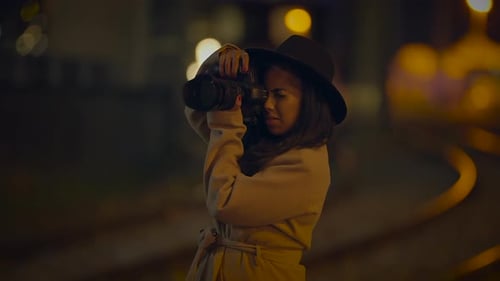 Woman Photographs with Camera at Night
