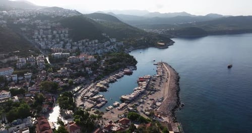 Luftumlaufbahn der Küste von Kas in Antalya, Türkei, mit Booten im Hafen und in der Berglandschaft