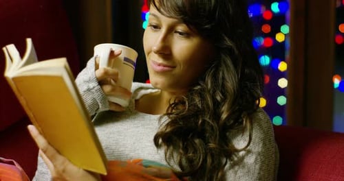 Woman Reads and Drinks During Christmas Time