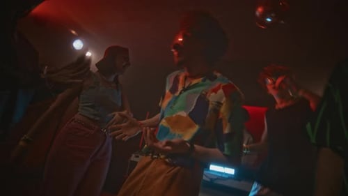 Zeitlupe eines Hipster-Typen, der während einer Retro-Party im Nachtclub in der Menge tanzt