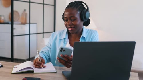 Woman Studying and Taking Notes at Home