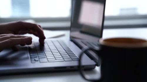 office worker working at computer and drinking coffee while sliding right to left