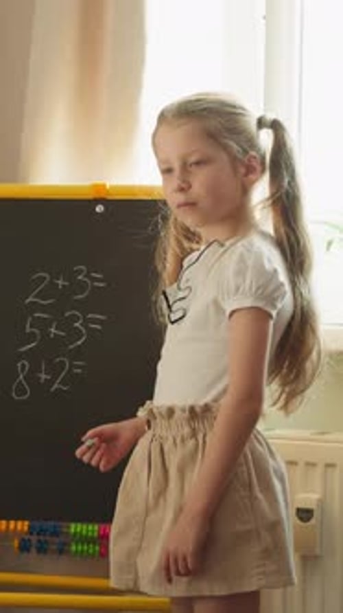 Young Girl Solving Math Problems on Chalkboard