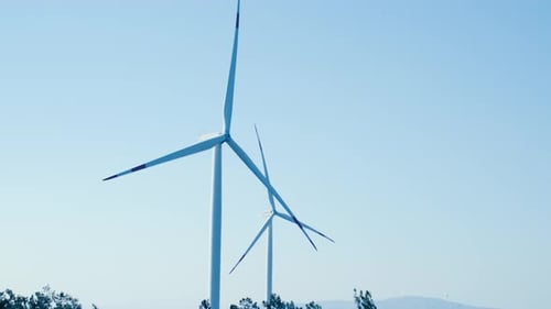 Close up shot of spinning wind turbine blades generating green renewable energy on a wind farm.
4k .