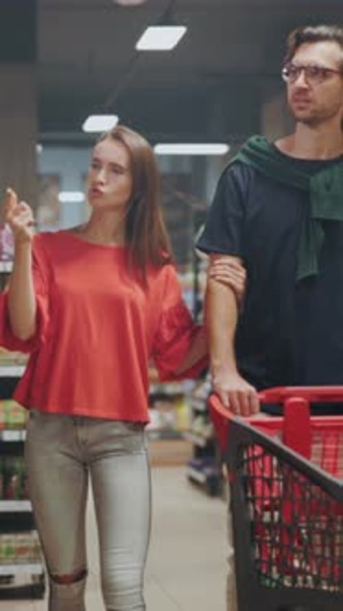 Man and Woman Choosing Products Together Young Pair Browsing and Selecting Goods in Cozy Supermarket
