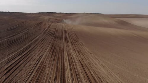 Green tractor planting sunflower on the sandy field in Ukraine 4K