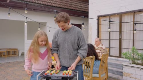 Multiracial family having fun and enjoying party outdoors in garden.