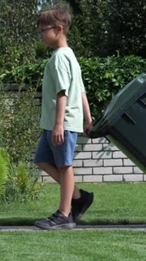 Vertical Video Boy Rolls Out Trash Can Boy Throws Out Garbage
