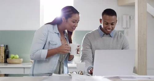 Happy married couple looking at home on laptop and wife showing a kitchen design on a real estate