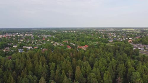 View at small hidden town in vivid coniferous forest, Latvia, dolly back