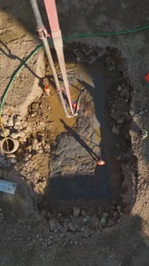 Vídeo vertical: maquinaria pesada y equipos cualificados trabajando en la preparación de los cimientos