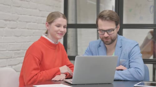 Team Collaborates Using Laptop in Modern Office