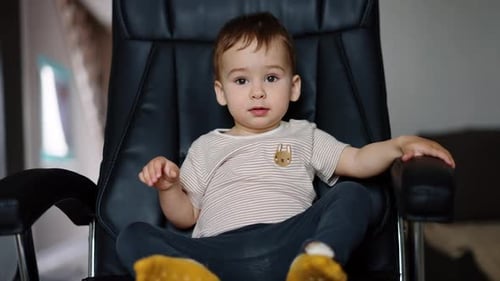 Young Child Sitting in a Large Office Chair