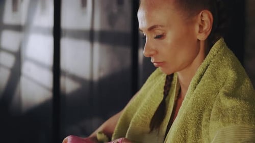 Entschlossene Sportlerin wickelt sich die Hände