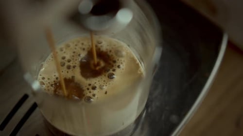 Coffee Pouring From Machine Into Glass