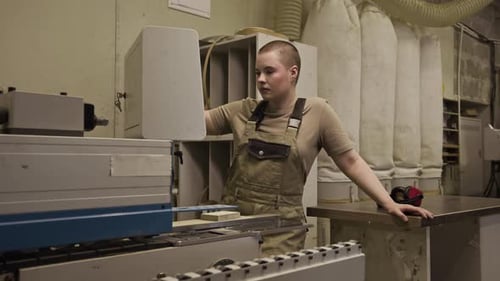 Young Woman Operating Edge Banding Machine in Woodworking Workshop