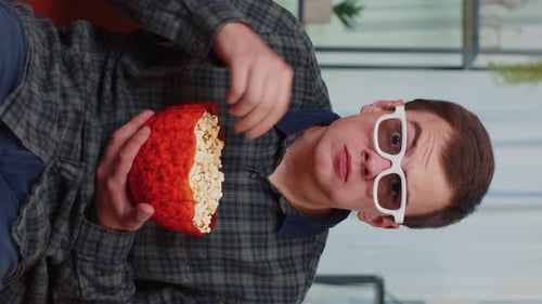 Young Adult Enjoying Popcorn While Watching Movie