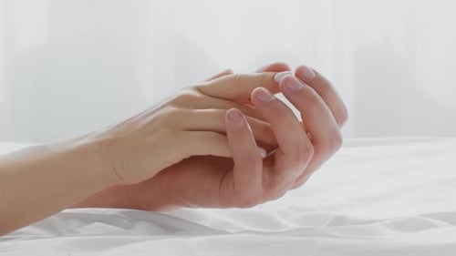 Young Couple Showing Affection in a Cozy Bedroom Setting